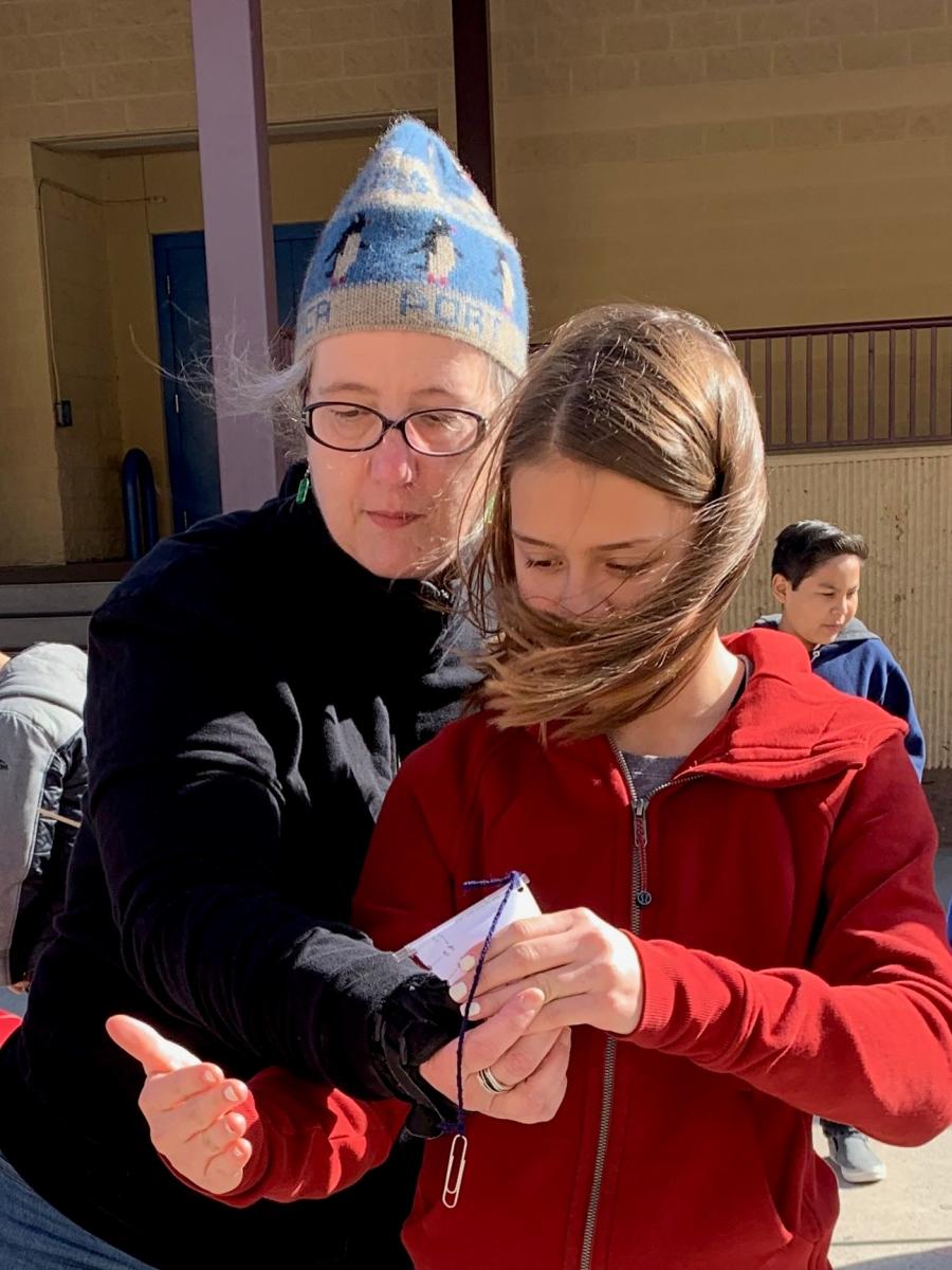 NCSE Teacher Ambassador Turtle Haste engages in a hands-on, inquiry-based activity outside with a student.