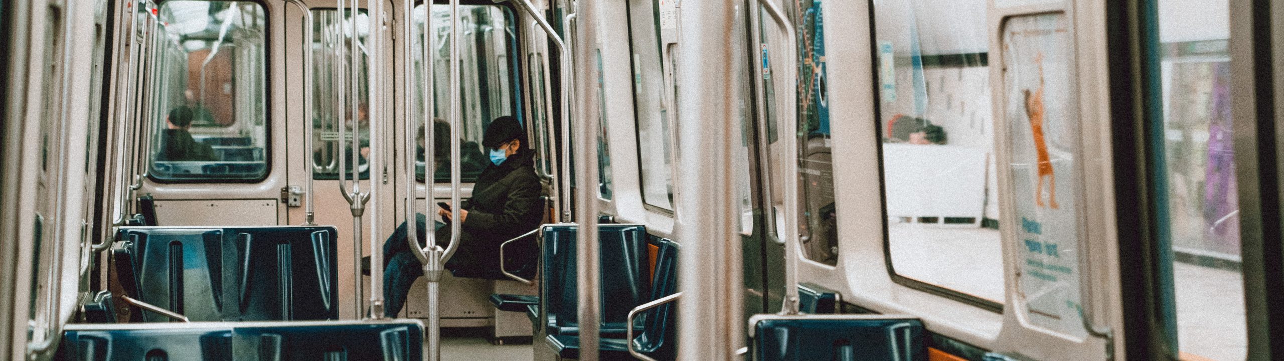 Person wearing a mask on a commuter train