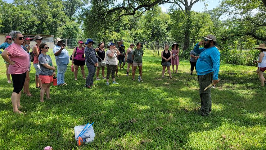 Teachers receiving instruction on methods for obtaining tree core samples.