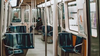 Person wearing a mask on a commuter train