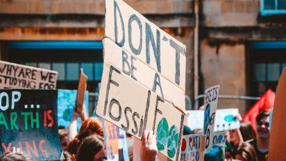 Climate change activists holding up signs.